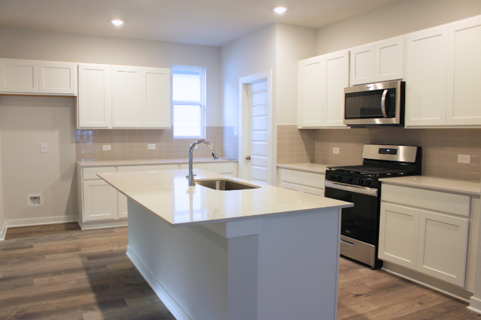 A kitchen with white cabinets.
