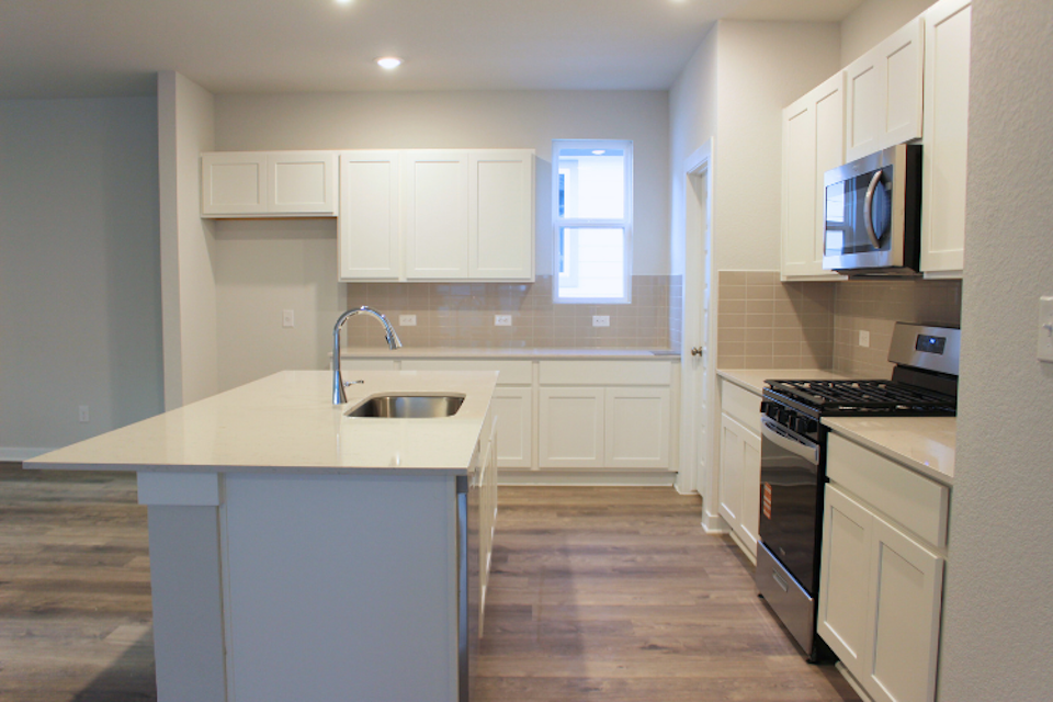A kitchen with white cabinets.
