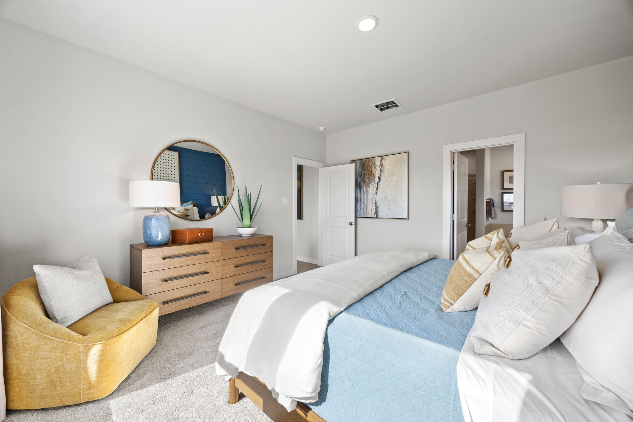 A bedroom with a bed and a chair.