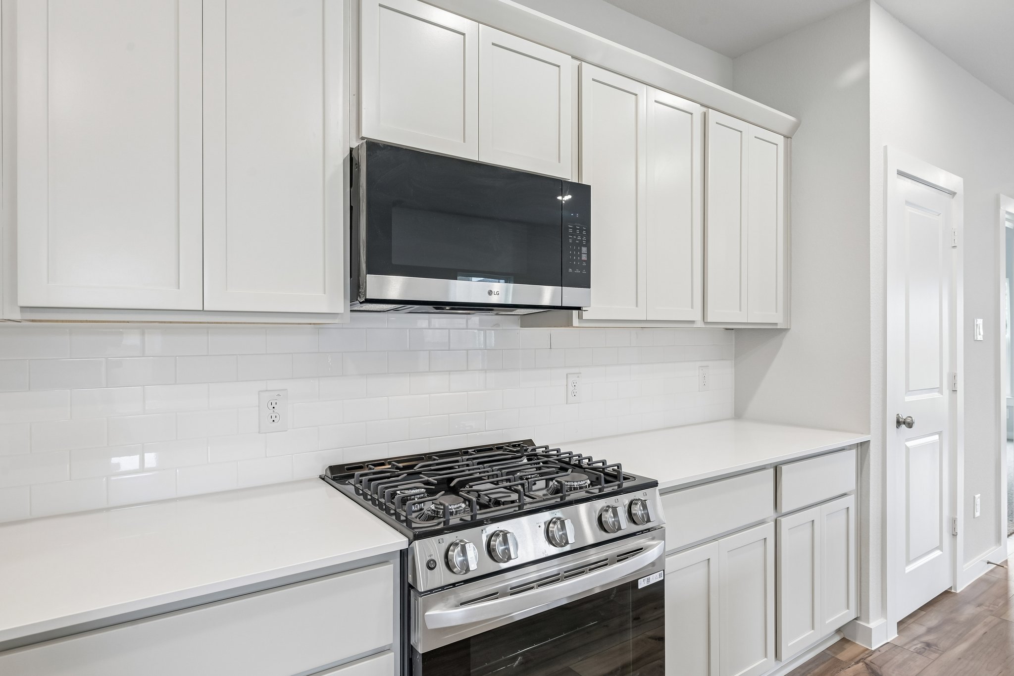 A kitchen with white cabinets.