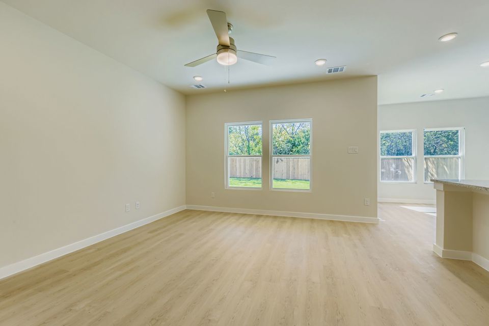 A room with a wood floor and a ceiling fan.