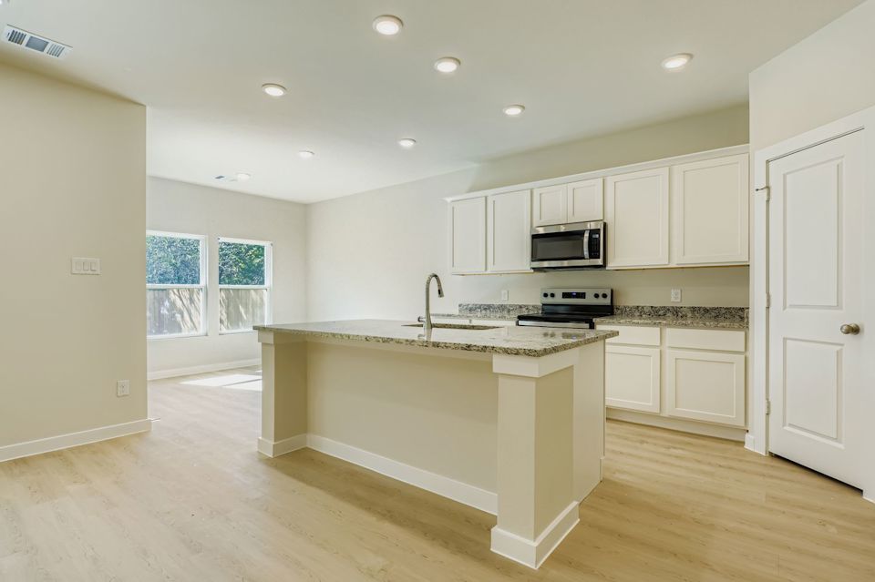 A kitchen with white cabinets.