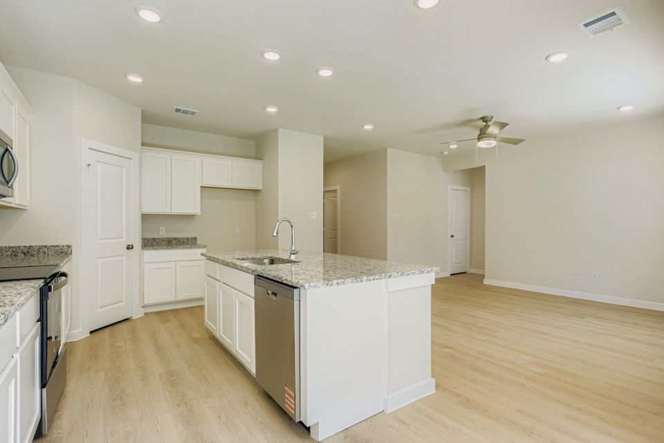 A kitchen with white cabinets.