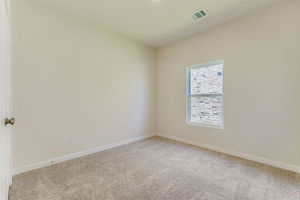 A room with a carpet and a window.