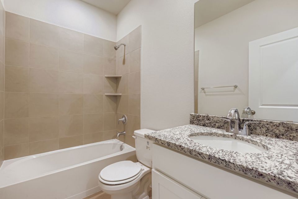 A bathroom with a tub sink and toilet.