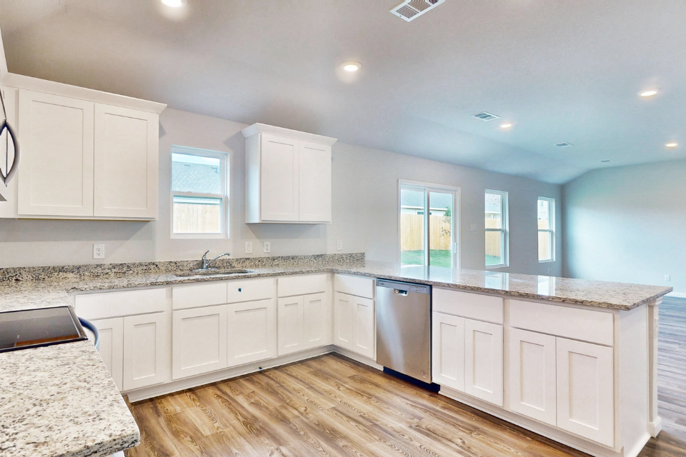 A kitchen with white cabinets.