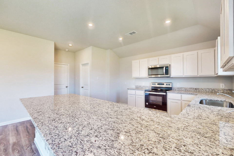 A kitchen with marble counters.