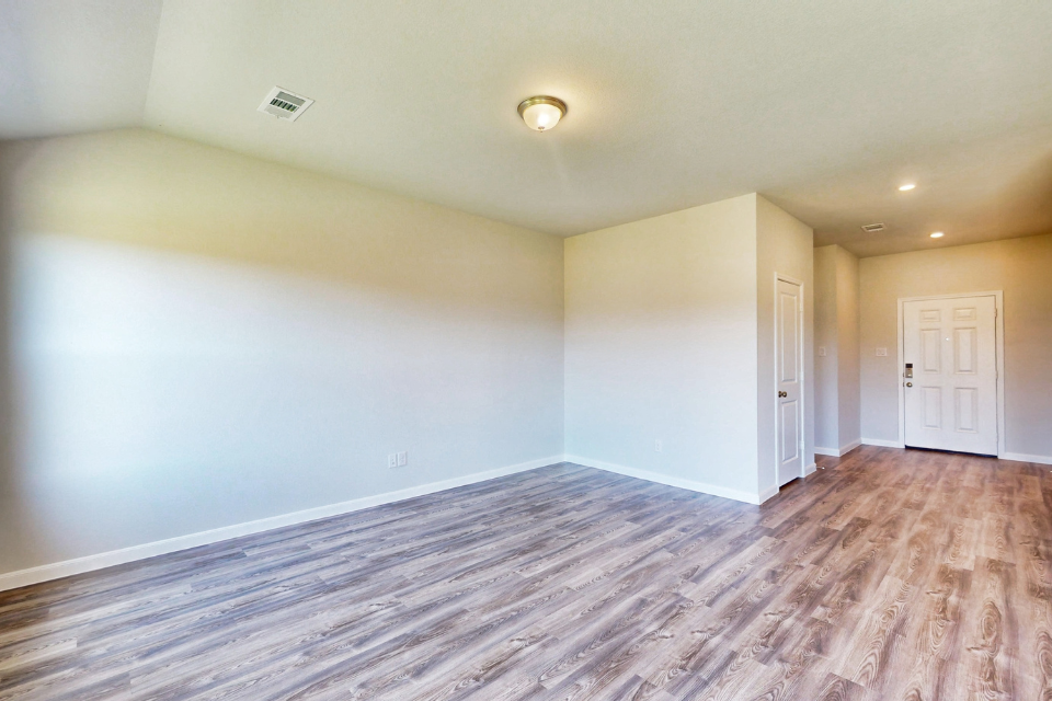 A room with a wood floor and white doors.