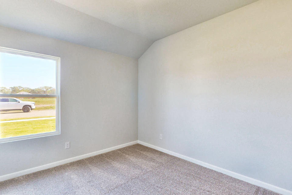 A room with a window and a car parked in it.