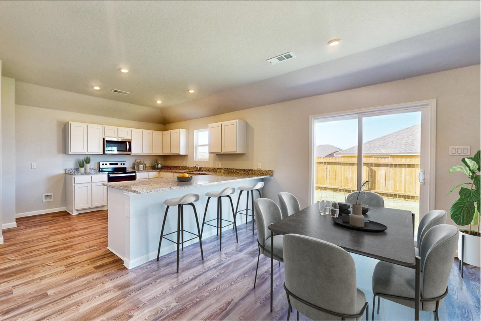 A kitchen with a dining table and chairs.