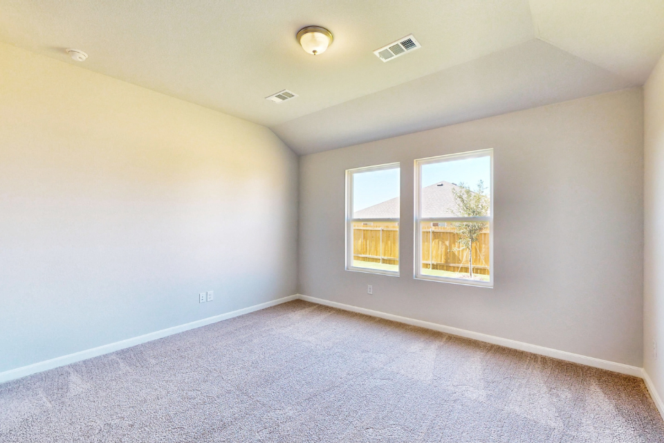 A room with a window and a light on the wall.