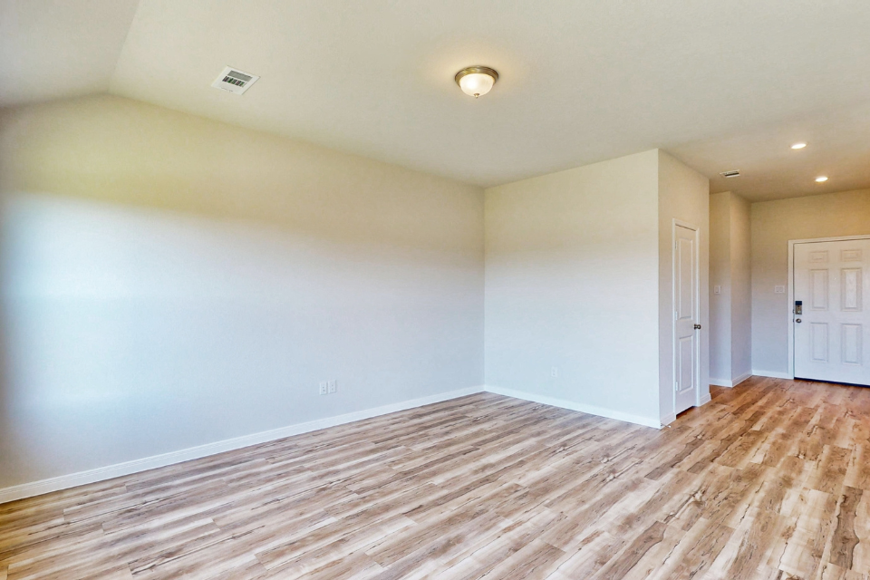 A room with a wood floor and white walls.