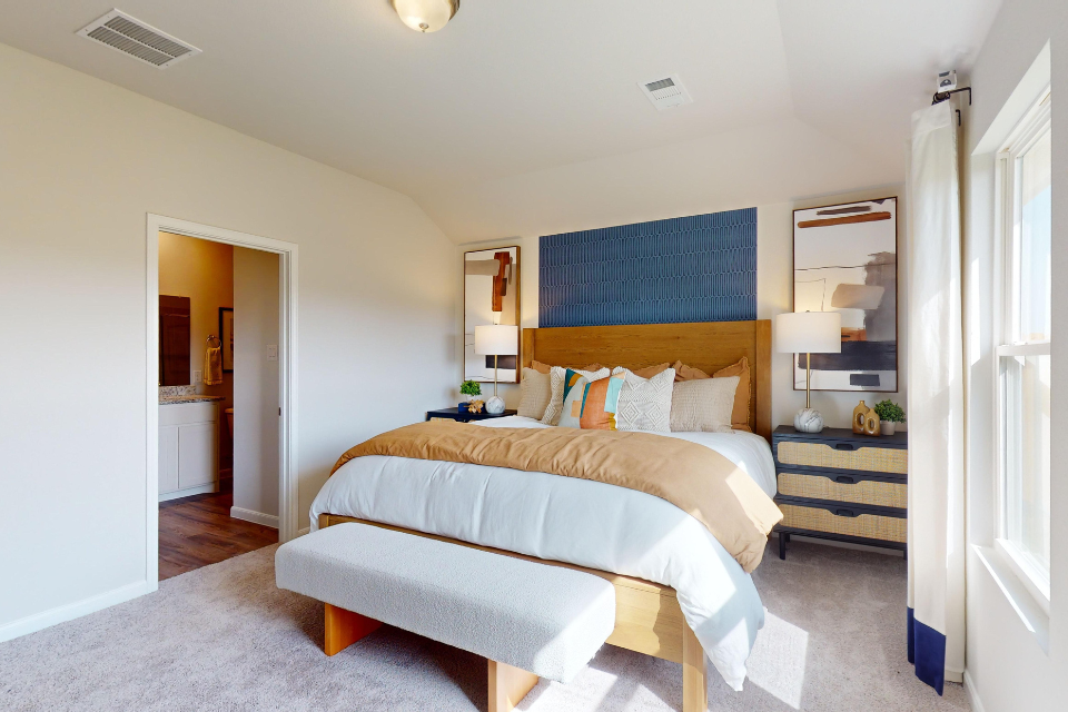 A bedroom with a bed and a bench.