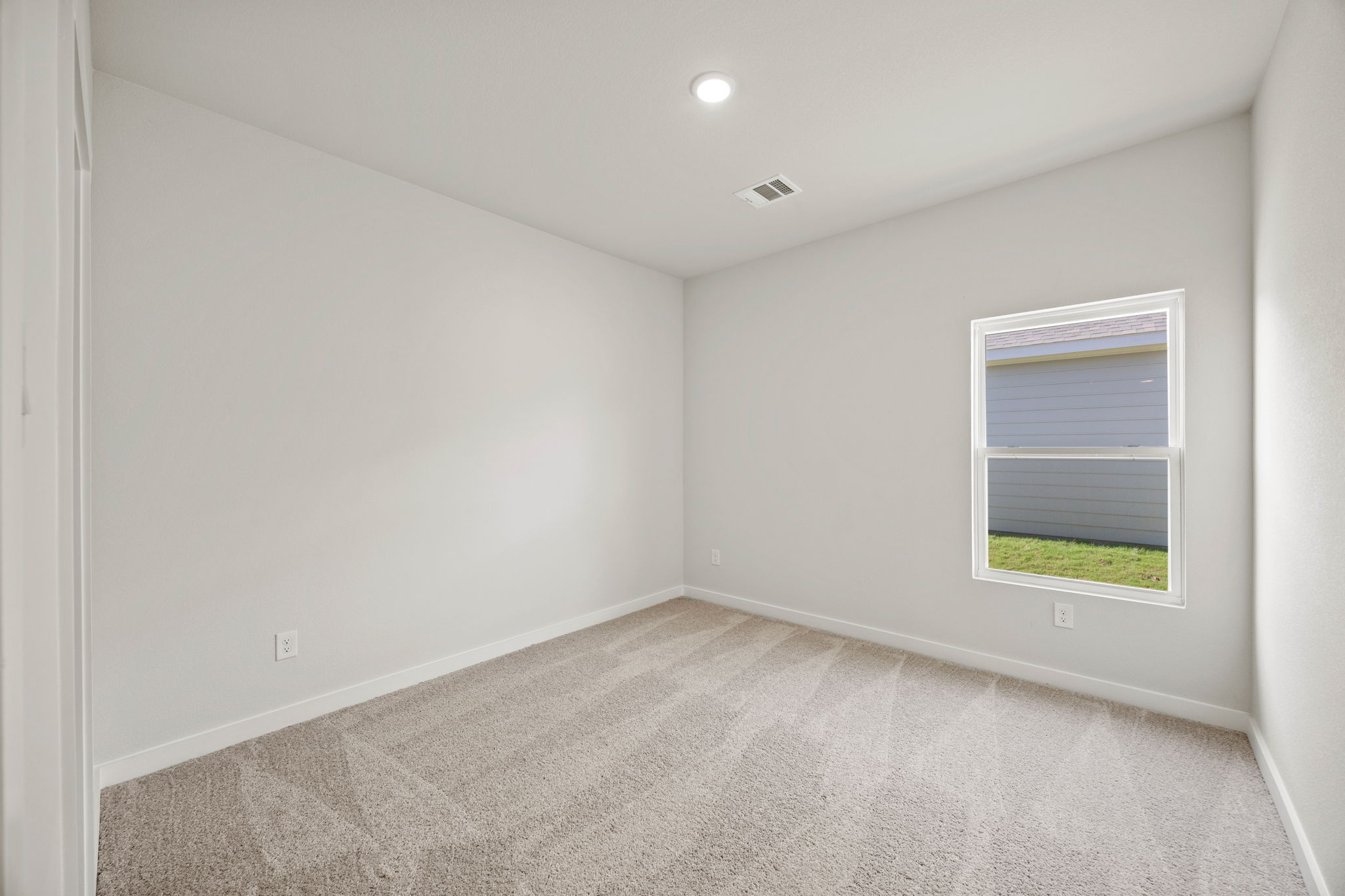 A room with a window and carpet.