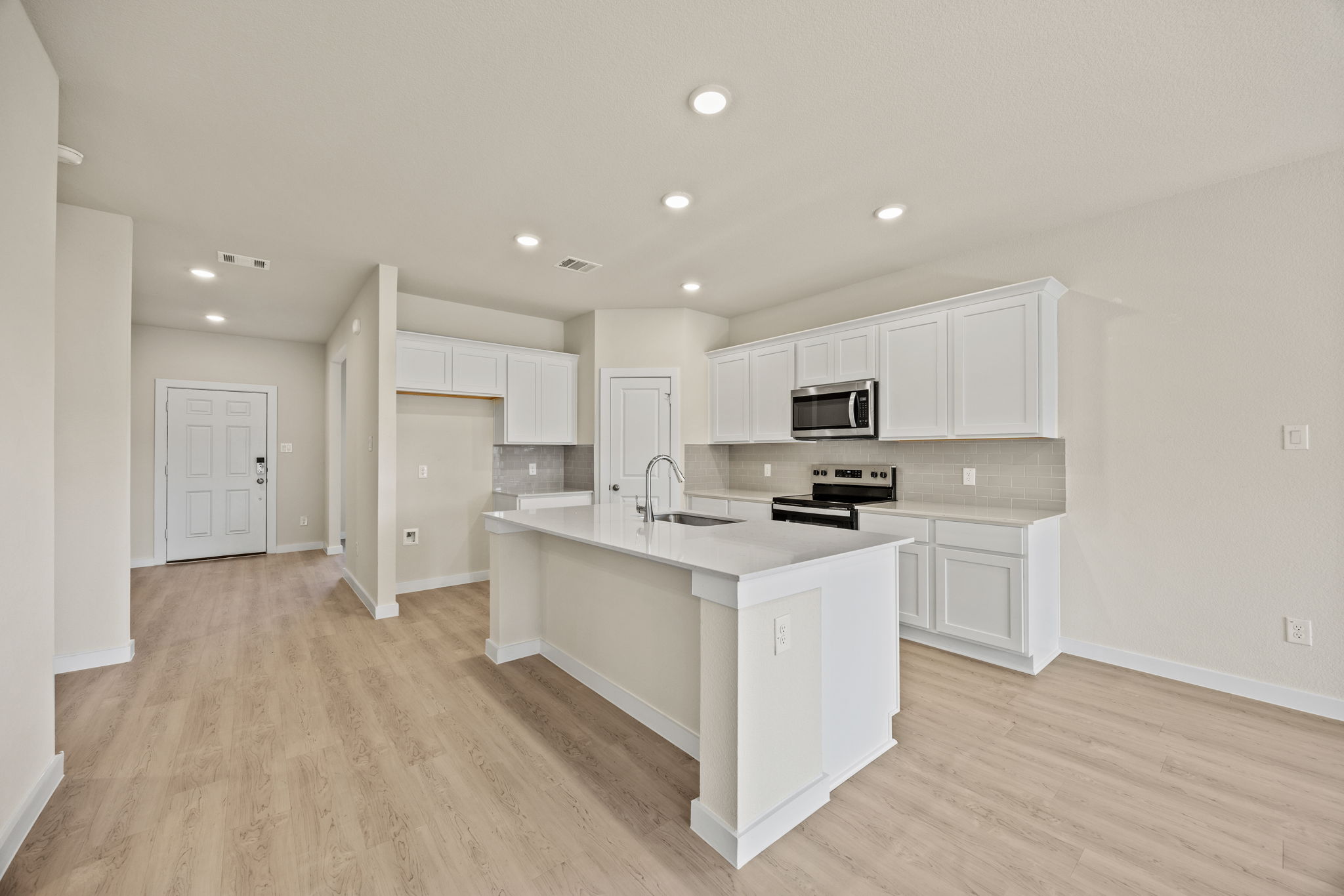 A kitchen with white cabinets.