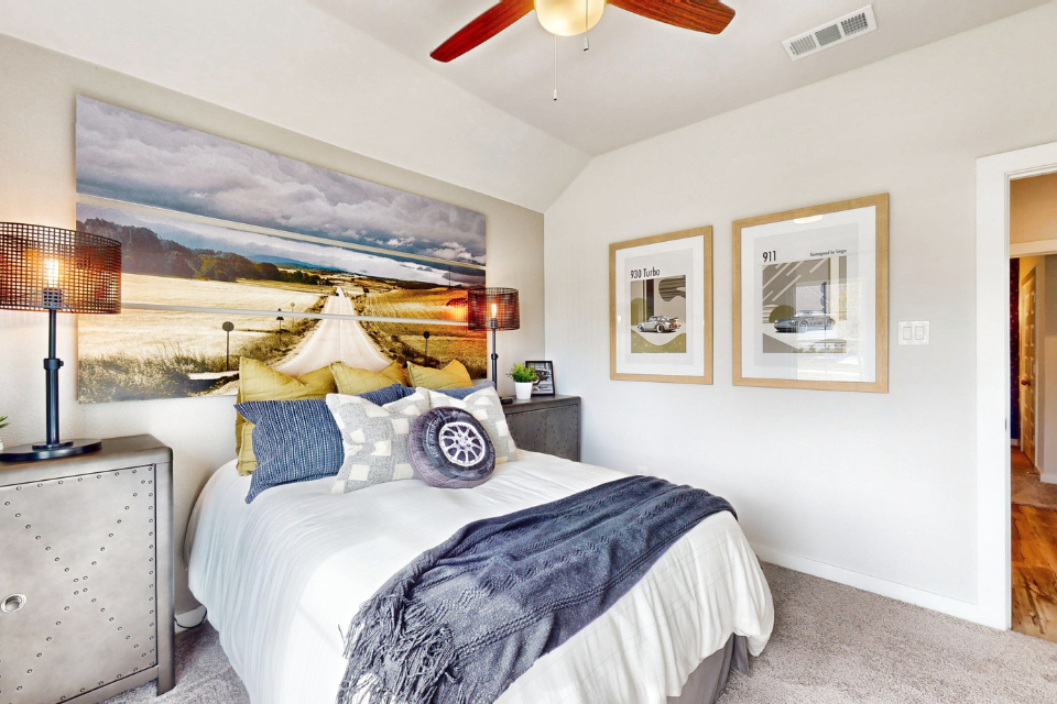 A bedroom with a large painting on the wall.