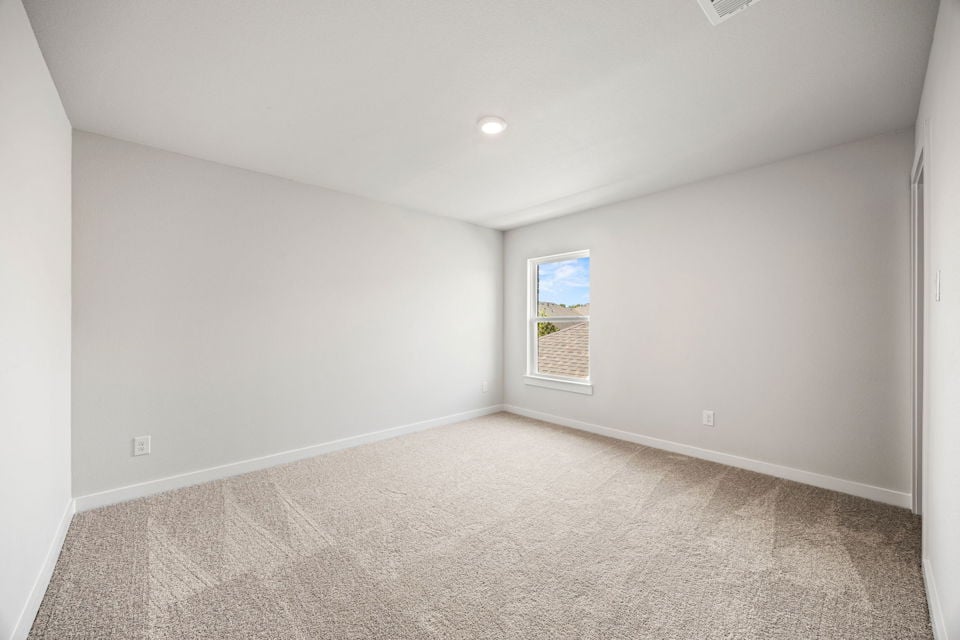 A room with a carpet and a window.
