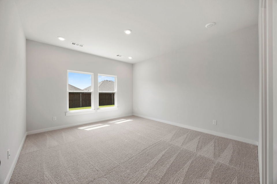 A room with a carpet and windows.