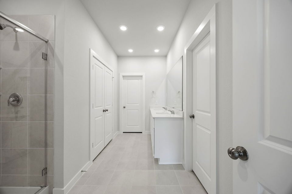 A bathroom with white cabinets.