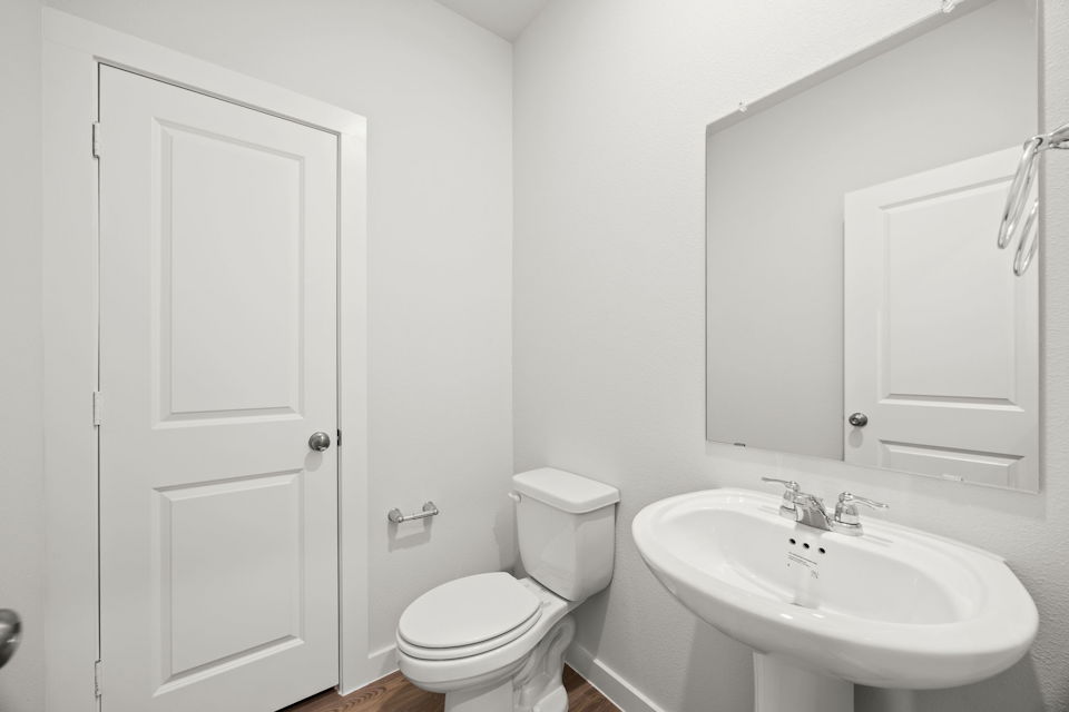 A bathroom with a toilet sink and a mirror.