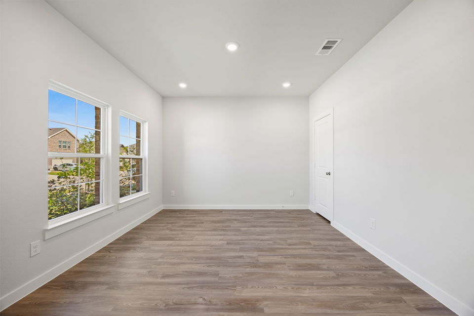 A room with a wood floor and windows.