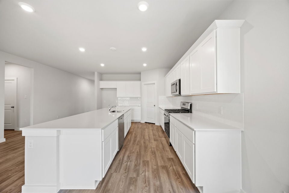A kitchen with white cabinets.