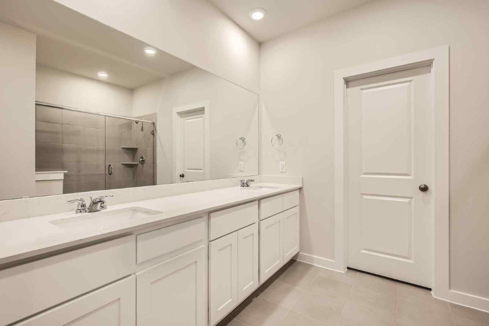 A bathroom with white cabinets.