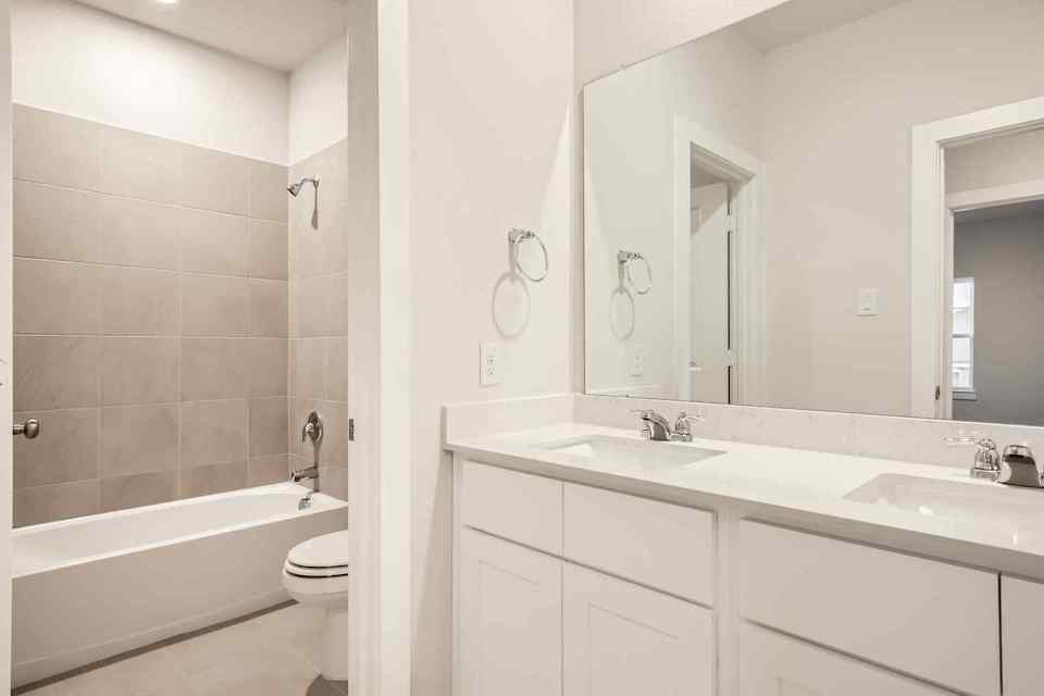 A bathroom with a tub sink and toilet.