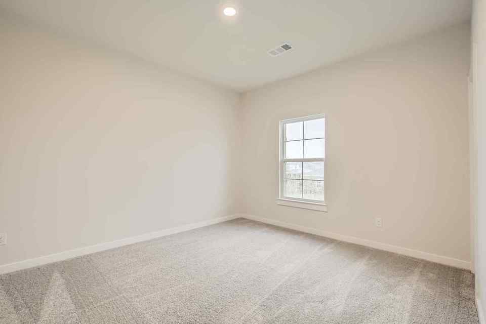 A room with a window and a carpet.