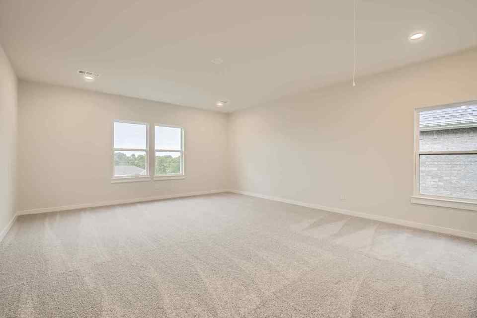 A room with a carpet and windows.