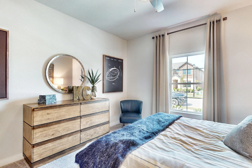 A bedroom with a bed and a chair.