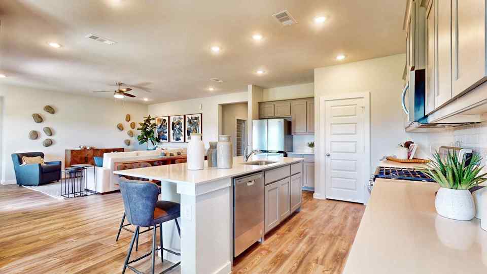 A kitchen with a bar and chairs.