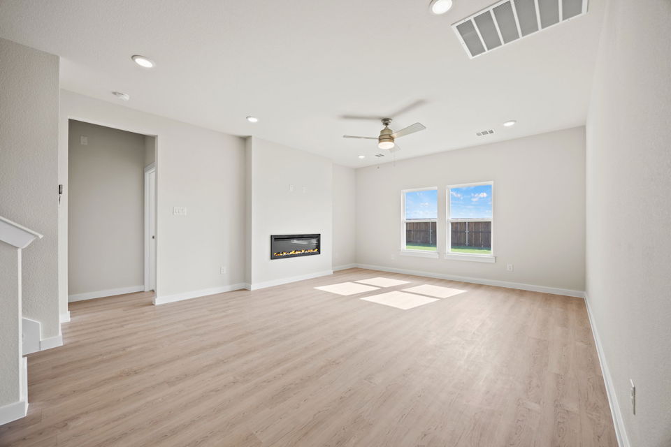 A large empty room with a wood floor and a wood floor.