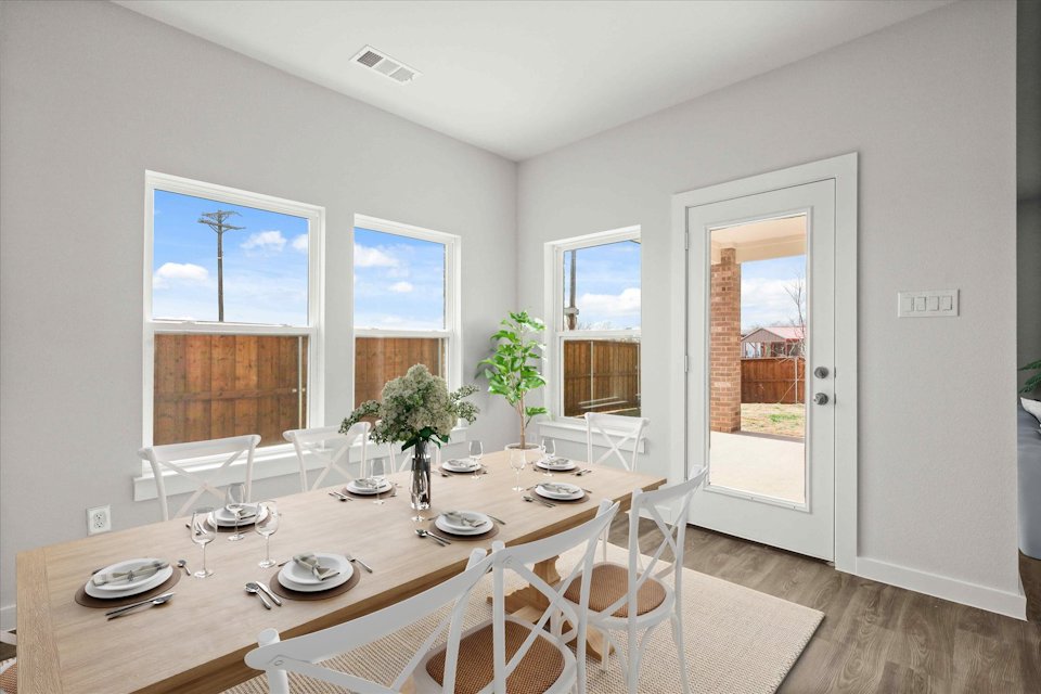 A dining room table with white chairs.