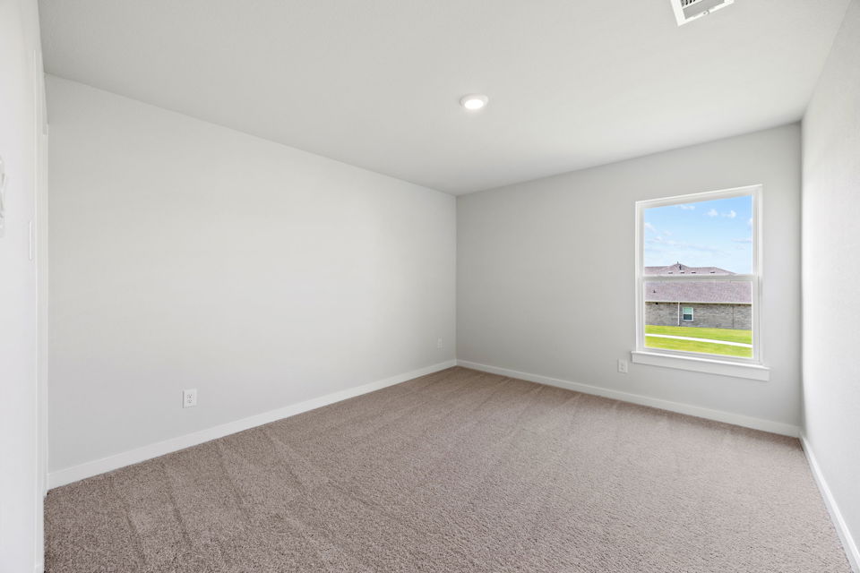 A room with a window and a carpet.