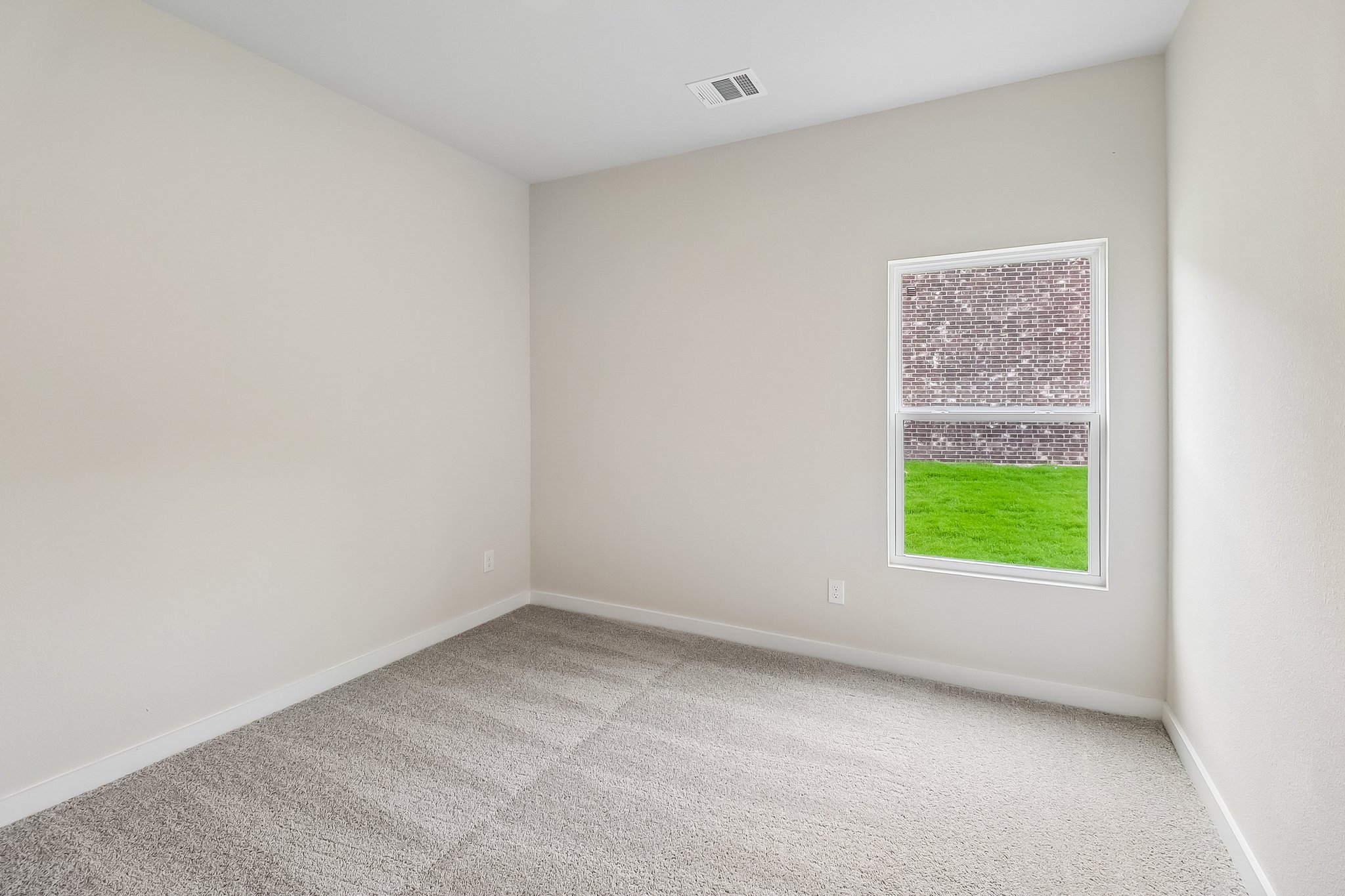 A room with a window and a green lawn.