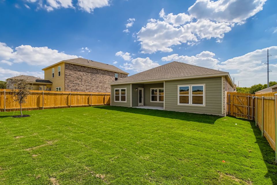 A house with a fence and grass.