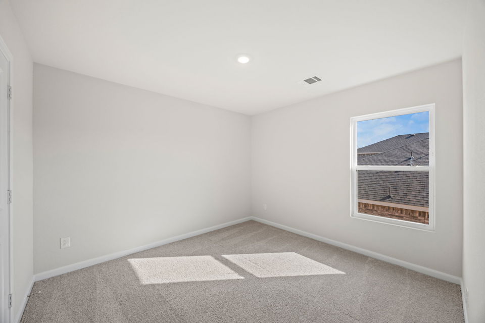 A room with a window and a rug.