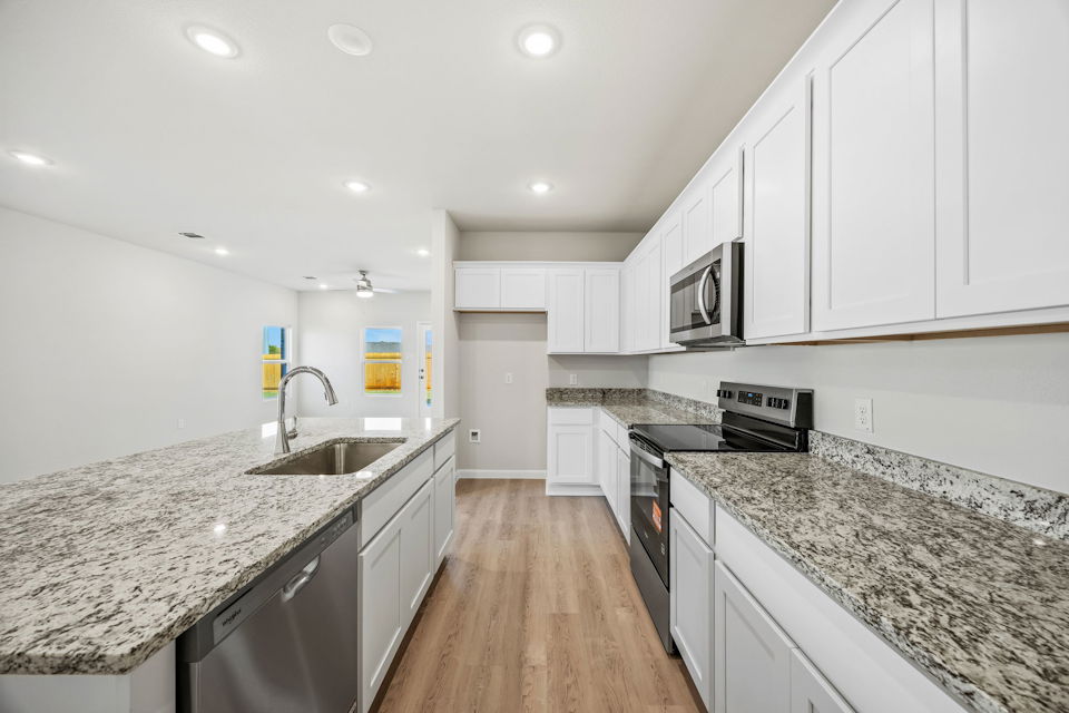 A kitchen with white cabinets.