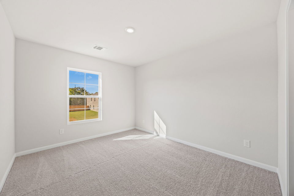 A room with a window and carpet.