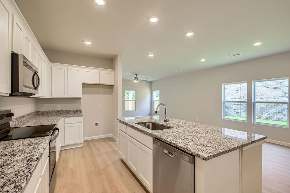 A kitchen with white cabinets.