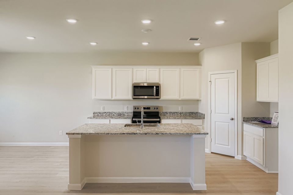 A kitchen with white cabinets.