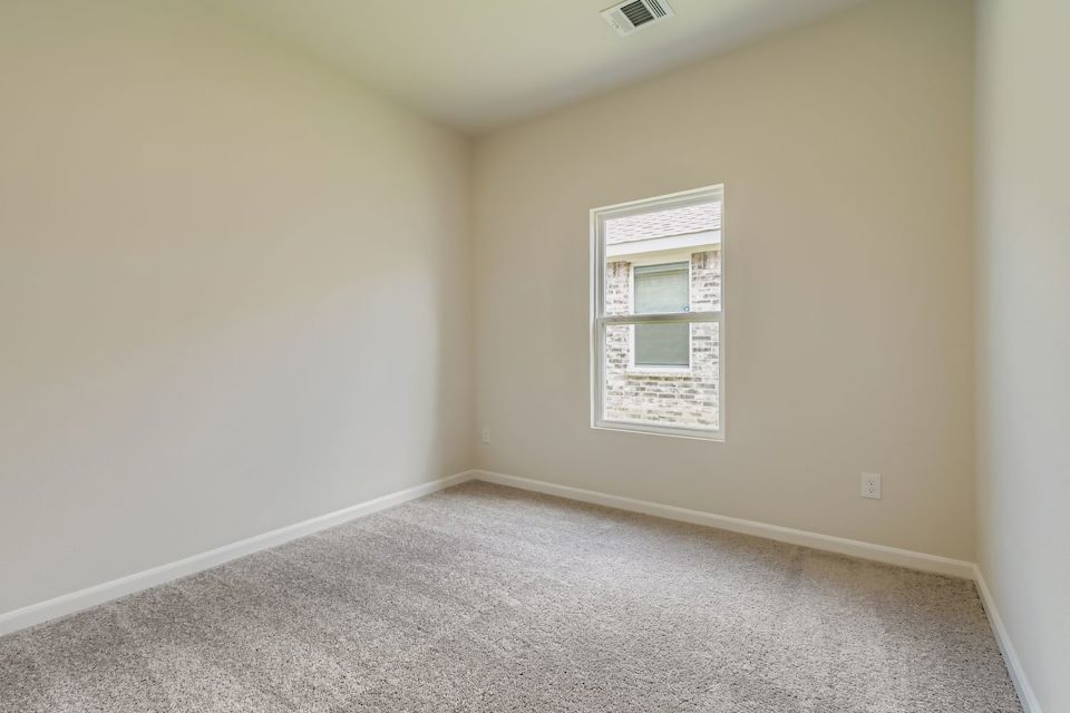 A room with a white wall and a window.