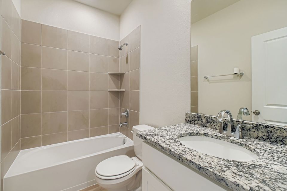 A bathroom with a tub sink and toilet.
