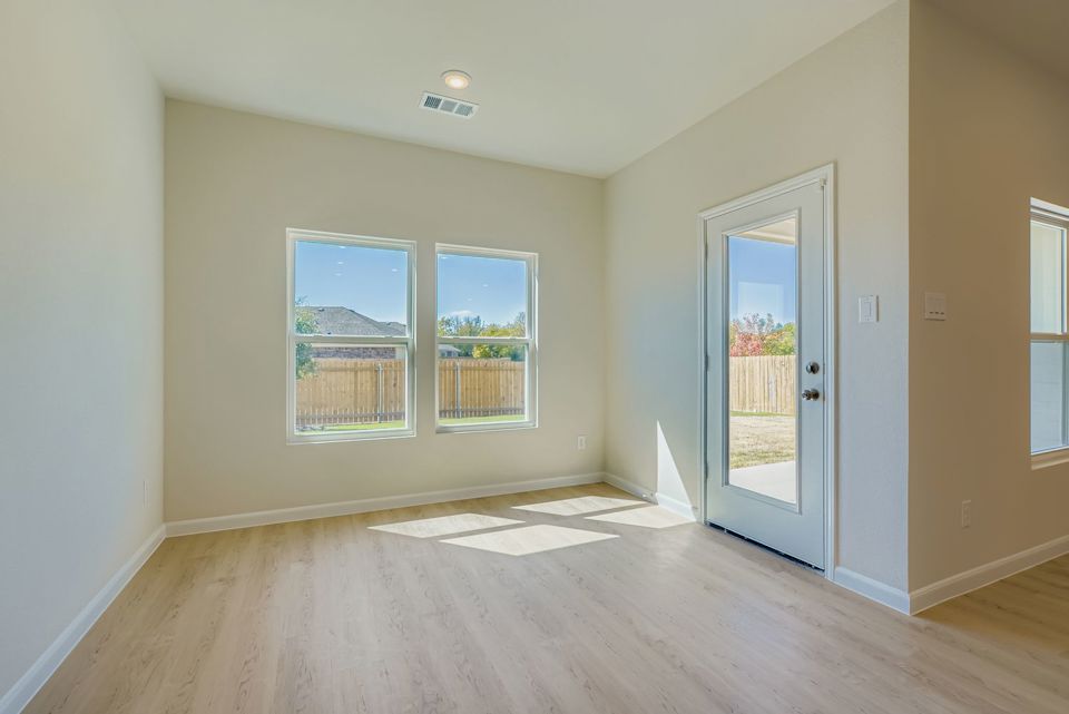 A room with a wood floor and a wood floor with a door open.