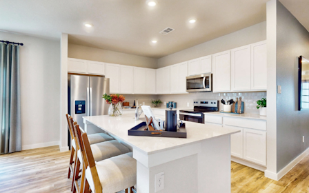 A kitchen with white cabinets.