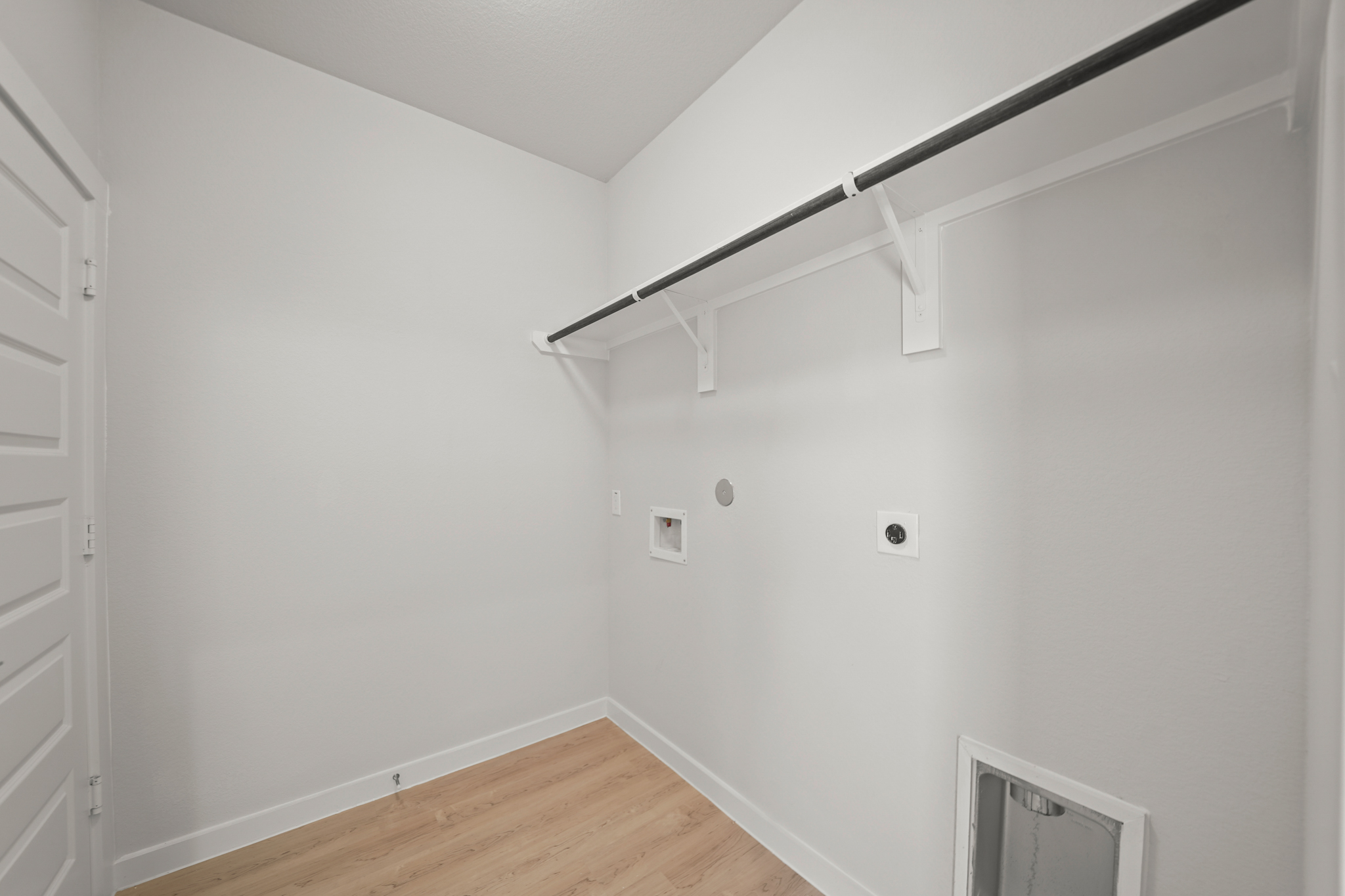 A white room with a wood floor and white walls.