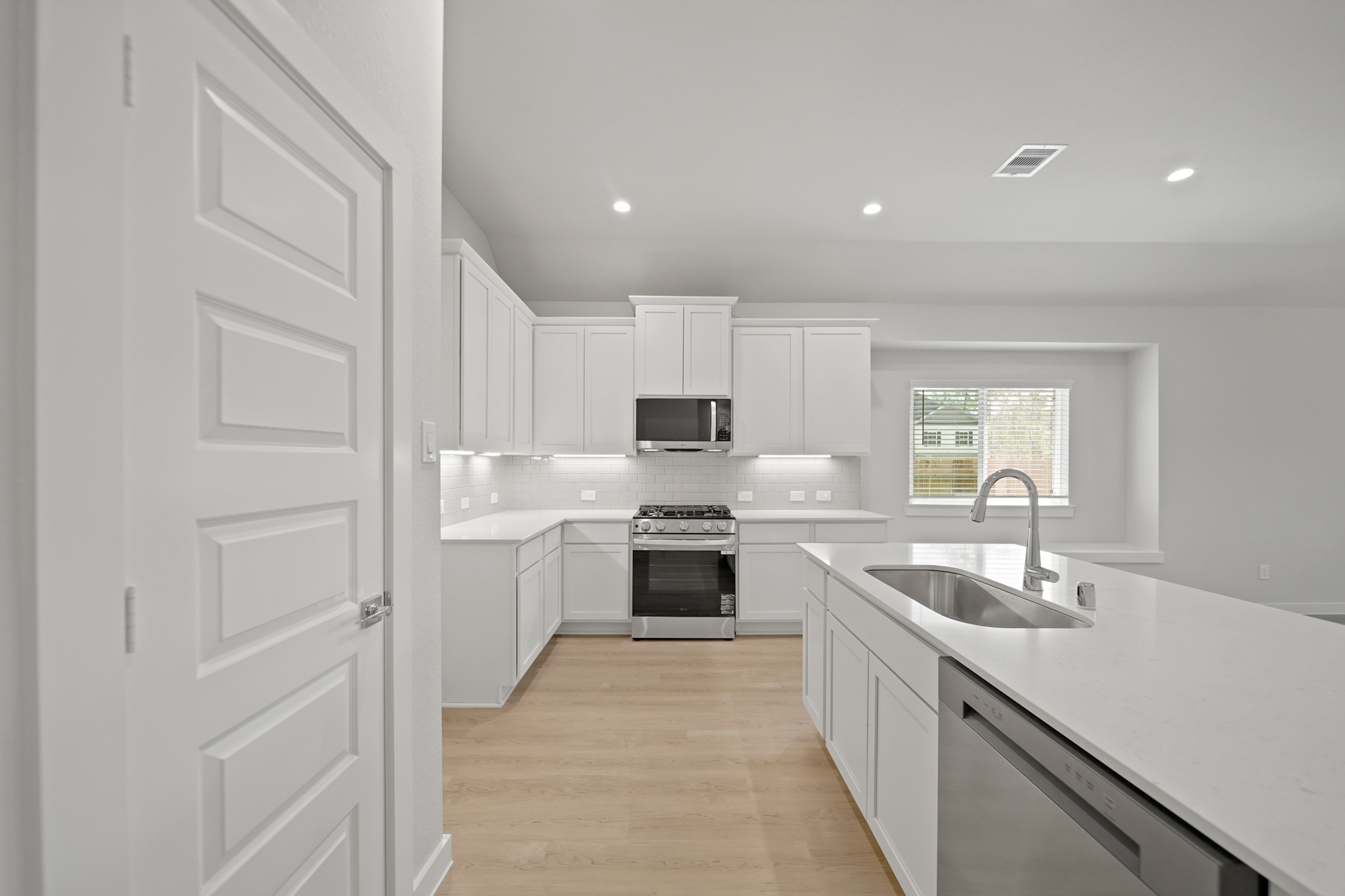 A kitchen with white cabinets.