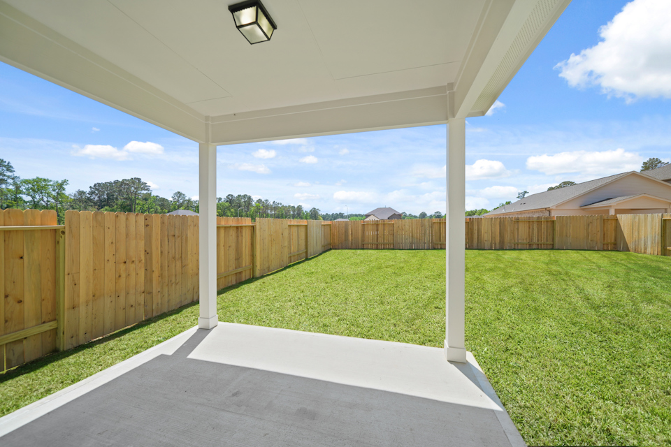 A fenced in yard with a wood gate and a light post.