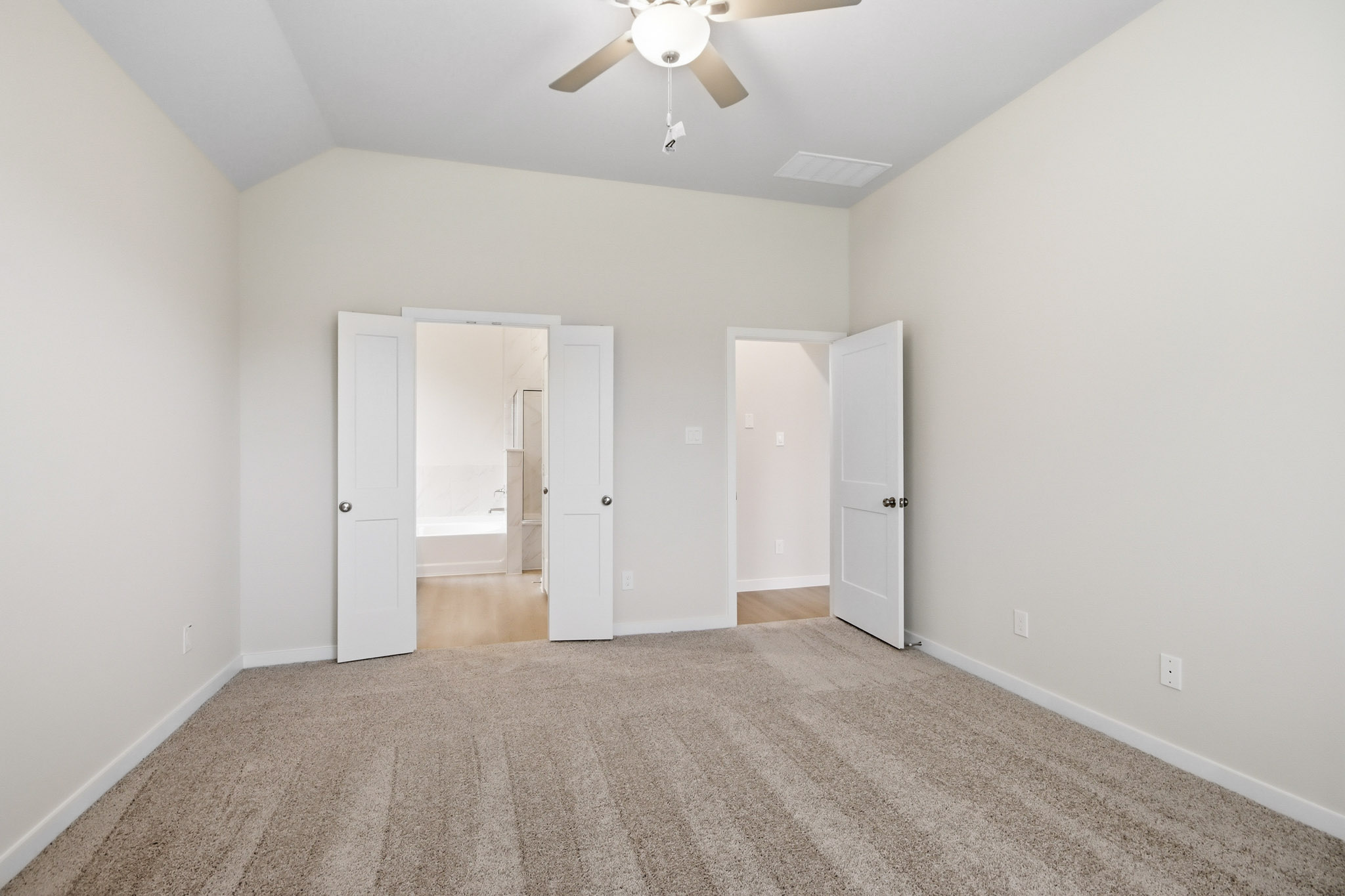 A room with a ceiling fan and a door.